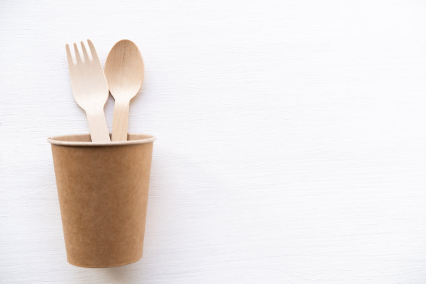 白色背景上的环保一次性厨具。木制的叉子和勺子放在纸杯里。32、生态环保，零浪费理念。前视图。平躺图片下载