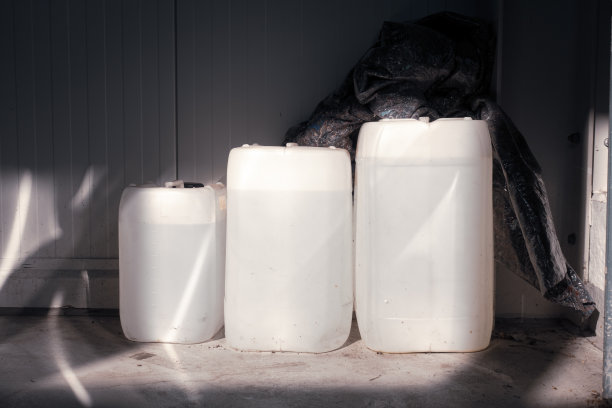 三个装满不同大小的白色罐子立在一个车间的墙上图片下载