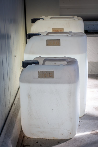 三个装满不同大小的白色罐子立在一个车间的墙上图片下载