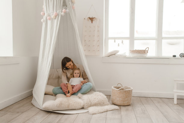 可爱的小女孩和她的妈妈在一个极简的儿童房间里玩耍。图片下载