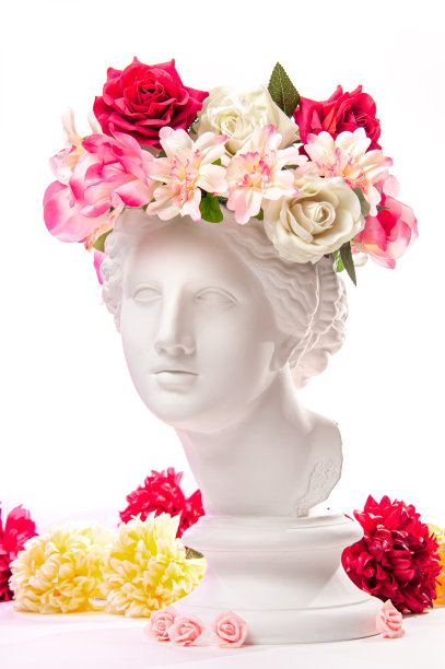 美丽年轻的女性脸庞和五彩缤纷的鲜花。石膏古董半身像的维纳斯花环。美丽的春夏模特女孩带着清新的花束。图片下载