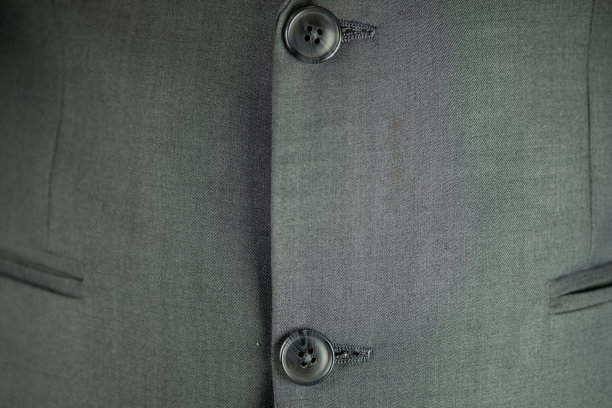 一个男人西装背景上的黑色按钮的特写。图片下载