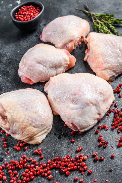 生鸡腿带皮，有机肉。黑色背景。俯视图图片下载