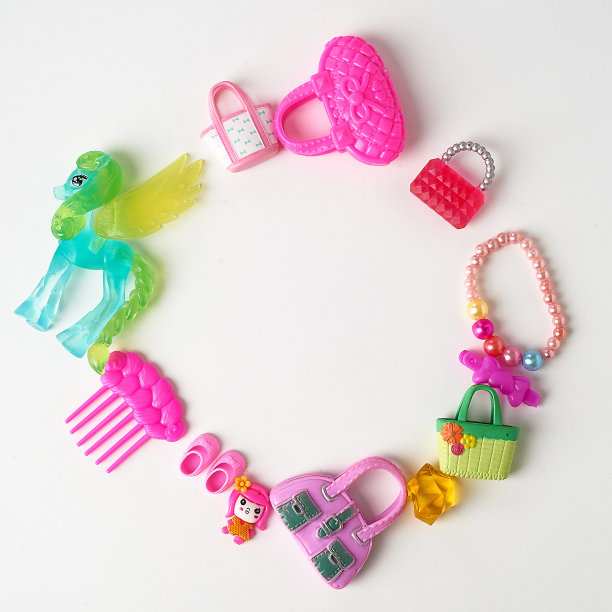 粉色小女孩的玩具。扇贝，手袋，马，珠子。孩子们的财富。在白色背景上排成一排图片下载