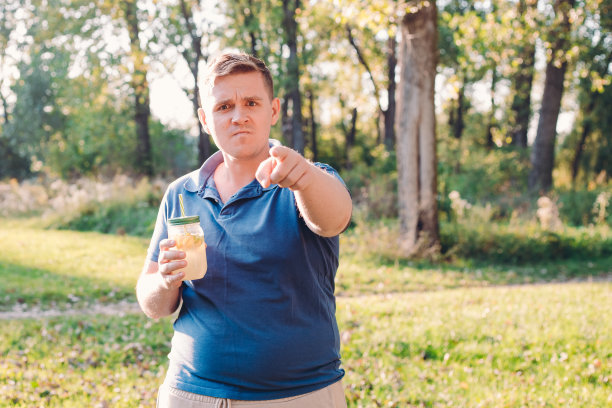 一个在户外的不开心的人喝了一杯自制的柠檬水。维生素和规律生活理念。年轻的疯子喝着莫吉托。图片下载