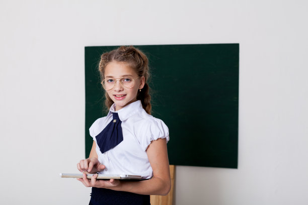 女学生在绿板上用平板电脑上课图片下载
