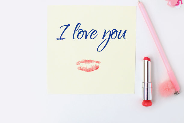 平铺:黄色的纸，粉色的笔，绒球，口红，心形彩纸，唇印，我爱你的文字。在信封里制作情人节明信片。做你自己。系列图片图片下载