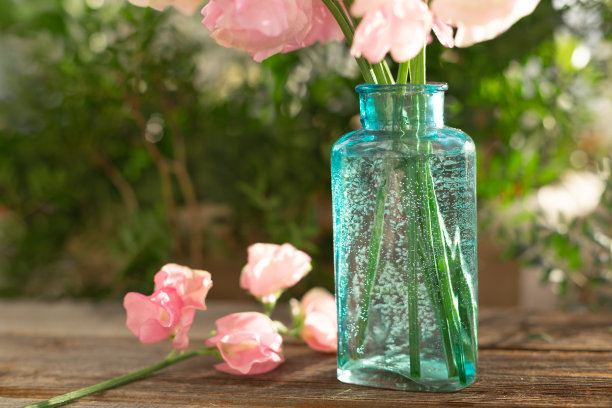 一束粉红色的甜豌豆在美丽的透明花瓶上木制的背景。家花园,乡村。春天的概念。3月8日的国际妇女节和2月14日的情人节图片下载