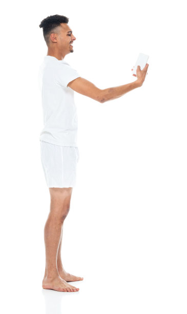 非裔美国青年男性穿着内衣站在白色背景前用手机拍照图片下载