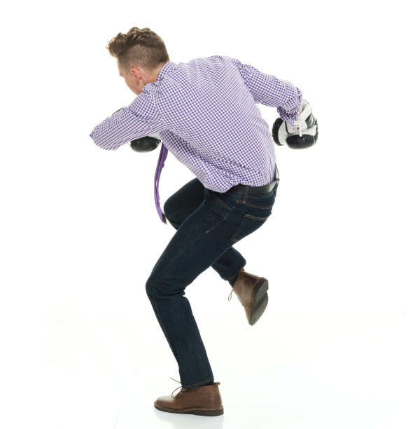 白人年轻男性商人戴着拳击手套站在白人背景前图片下载