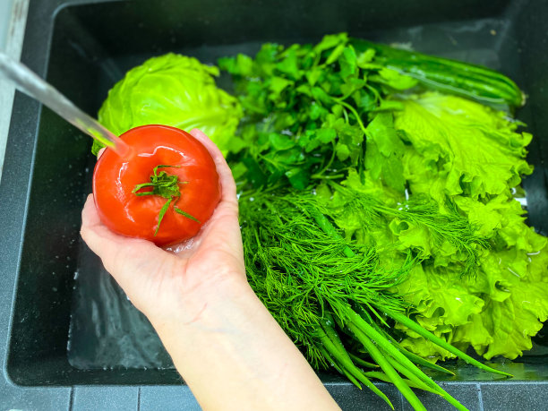 蔬菜在厨房的水槽里，里面装满了水。图片下载