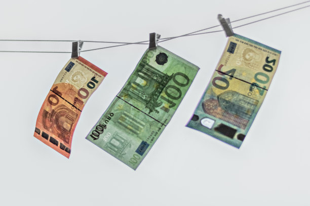 欧元钞票挂在晾衣绳上，背景是白色。绳子上绑着白色衣夹的欧元。用欧元洗钱的钱被张贴晾干。孤立的欧元货币在弦上。图片下载