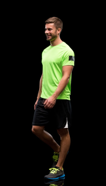 白人年轻男性运动员穿着跑步短裤走在黑色背景前图片下载