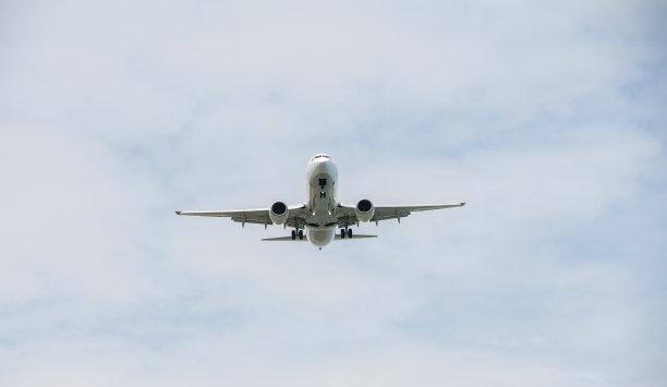 客机在飞行中。飞机在云层之上的高空飞行。飞机的底部视图。图片下载
