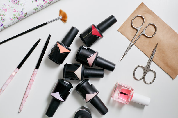 美甲师的收藏。不同颜色的指甲油，剪刀和刷子图片下载