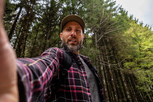 一名男子在美丽的云杉森林里自拍图片下载