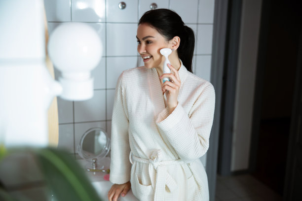 快乐的女人按摩脸在室内库存照片图片下载