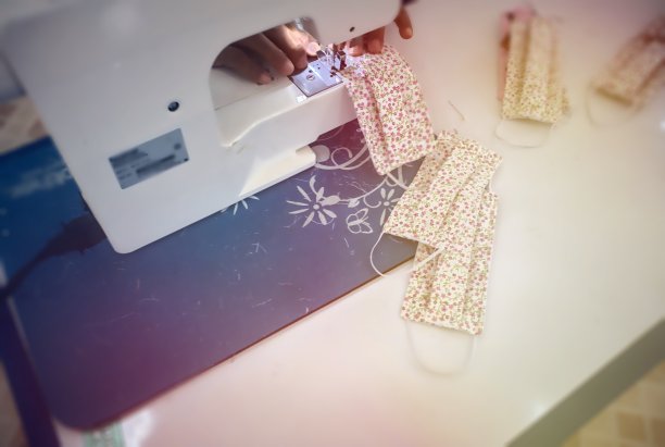 电动白色缝纫机，缝布罩，日光布罩，小花图案在白色桌上缝灯图片下载