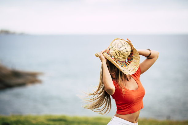 快乐理念与欢快的女孩跳舞户外红色衬衫和时尚的帽子-海洋和地平线的视野户外快乐休闲活动图片-自由的人享受积极的生活方式图片下载