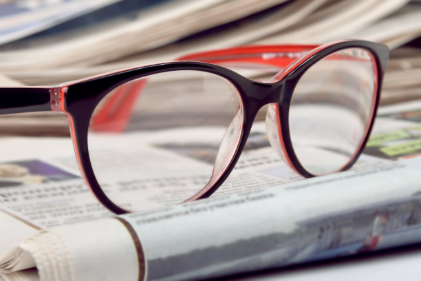 媒体新闻概念，眼镜为视觉和折叠报纸，近距离。素材图片