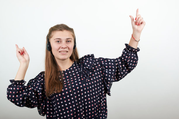 戴着黑色耳机听着音乐的女孩举手在山上跳舞图片下载