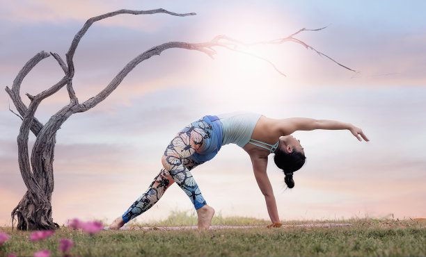 美丽的年轻女子在户外运动服装练习瑜伽的肖像。素材图片