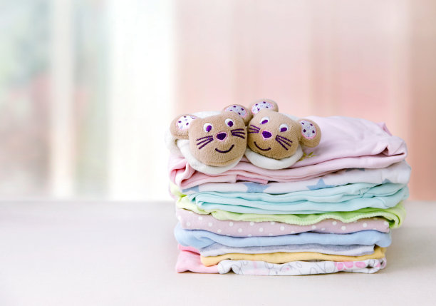 桌子上有一堆孩子的衣服图片下载