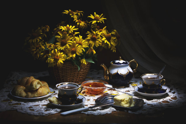 黑暗和穆迪静物与瓷壶，杯子，黄油，果酱，自制牛角面包和黄花在一个篮子图片下载