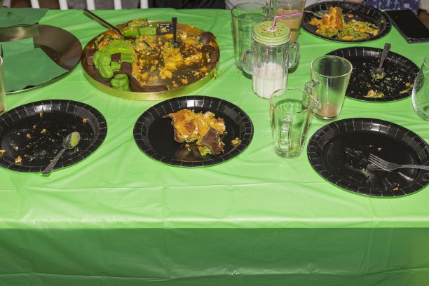 近距离观看桌子与黑色盘子上的蛋糕后生日派对。背景是绿色桌布。图片下载