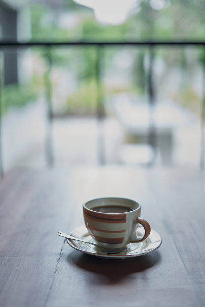 新鲜的早餐咖啡放在靠窗的木桌上图片下载