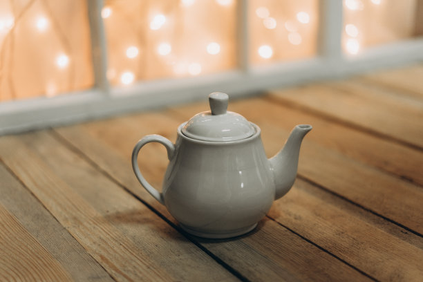 木质背景上的白茶壶图片下载