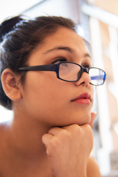 戴眼镜的悲伤女人沉思的特写。图片下载