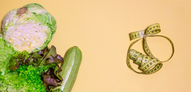 新鲜的绿色蔬菜的静物生活。西葫芦，卷心菜，生菜叶。在黄色背景。位于左边。空间的文本。垂直的照片。从上往下看图片下载