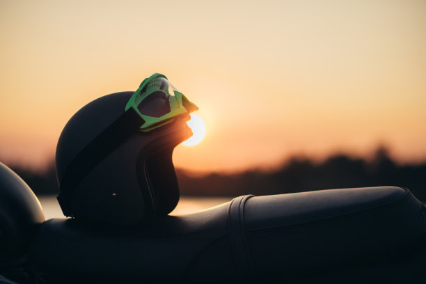 头盔和摩托车夕阳背景图片下载