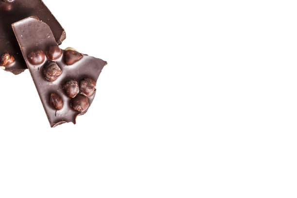 破碎的黑巧克力与大的榛子，孤立的白图片下载