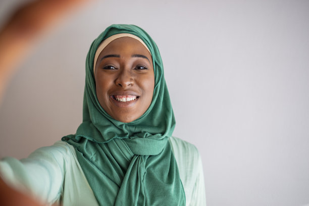 身着传统服饰的阿拉伯女子用手机自拍图片下载