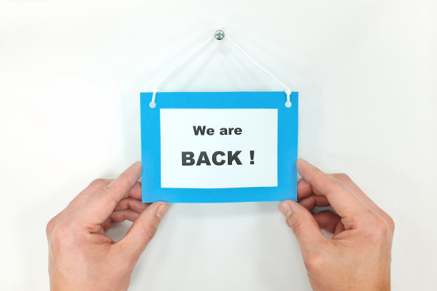 白色的门上挂着我们回来的标牌。回到商业概念。图片下载