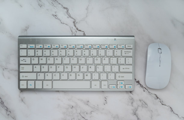 电脑键盘和鼠标隔离在白色大理石背景。顶部视图与复制空间。平的。办公室的概念图片下载