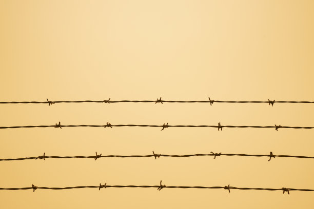 生锈的铁丝网映衬着尘土飞扬的沙漠般的天空图片下载