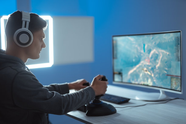 玩家戴着耳机在明亮的背景下玩电子游戏图片下载