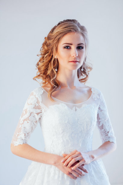 美丽的新娘摆着发型，穿着婚纱图片下载