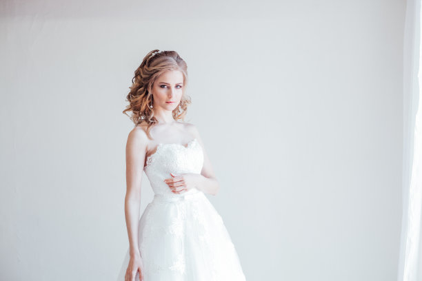 美丽的新娘摆着婚礼的发型和礼服图片下载