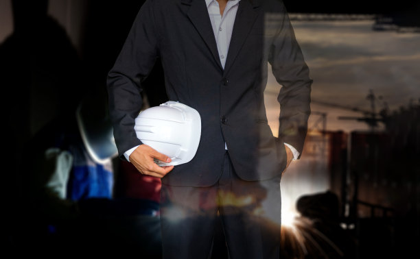 工程师或安全员持安全帽和焊工在施工现场车间对钢结构进行双重焊接。图片下载