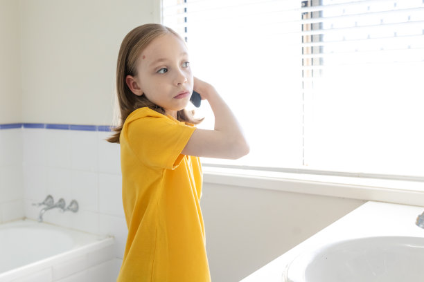 年轻的女学生正在梳头图片下载