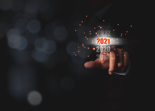 商人手指着以散景为背景的2021年虚拟筛选监视器，迎接新年的变化，开始新的目标和业务。图片下载