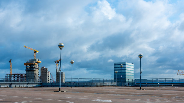 空的停车场与办公楼和建筑工地的背景。图片下载