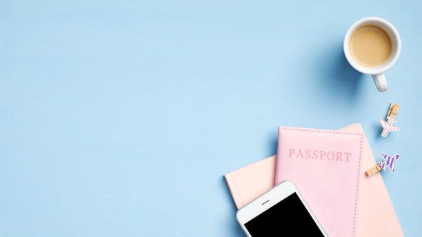 蓝色背景的咖啡杯、纸质笔记本、护照文件和智能手机。准备旅行的概念。平躺，俯视图图片下载
