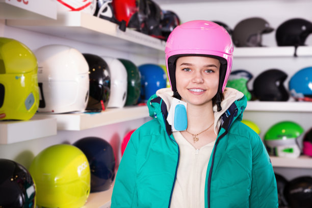 女孩在运动器材商店选购新的滑雪头盔图片下载