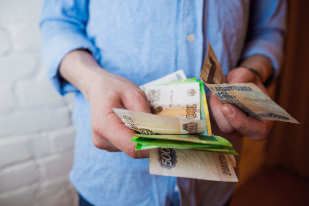 手里拿着俄罗斯卢布和小钱袋。健美的图片图片下载