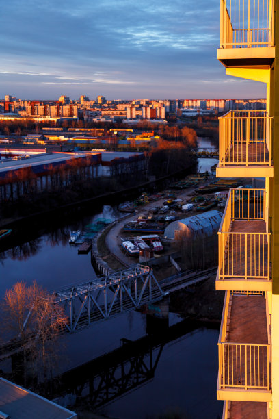 这是俄罗斯一个大型城市傍晚工业区的航拍照片，有仓库、仓库、办公室和建筑，背景是阳台。美丽的日落天空。图片下载